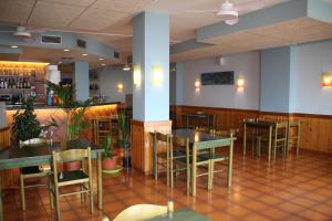 a restaurant with tables and chairs and a bar at Apartaments El Sorrall in Blanes