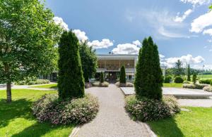 a garden with three trees in front of a building at Sannäsin Kartano in Porvoo