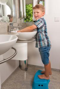 a young boy standing on a toilet in a bathroom at Klosterbräuhaus Ursberg in Ursberg