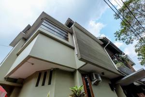 a white house with a window and a balcony at Buminanienie Guesthouse Bandung in Bandung
