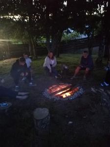 盧港的住宿－Looe Yurts，一群人坐在火坑周围