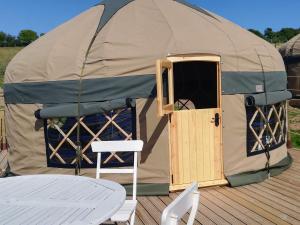 a yurt with a table and a table and a chair at Looe Yurts in Looe