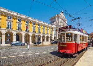 a red tram on a street in front of a building at Sunset Destination Hostel in Lisbon +16 photos