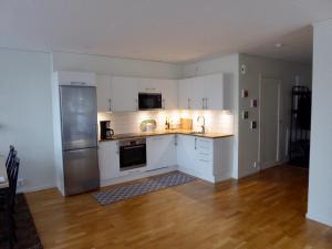 uma cozinha com armários brancos e um frigorífico de aço inoxidável em Fjällbacka Centralt em Fjällbacka