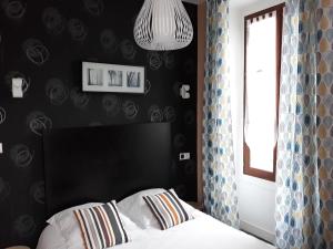 a bedroom with a bed with a black wall at Hôtel Ambroise in Uzerche