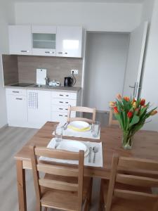 a kitchen with a wooden table with chairs and a tableasteryasteryasteryasteryastery at Eisenstadt Apartments in Eisenstadt