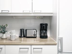 a kitchen counter with a coffee maker and a toaster at "ESPA" - Modern 1BR Apartment with Sauna, Balcony & Free Parking, Hosted by 2ndhomes in Tampere