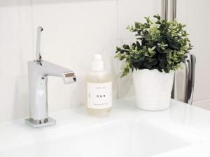 a white sink with a bottle of soap and a plant at "ESPA" - Modern 1BR Apartment with Sauna, Balcony & Free Parking, Hosted by 2ndhomes in Tampere +15 photos