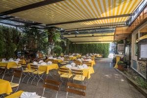 an outdoor restaurant with yellow tables and chairs at Gasthof Neuwirt in Ismaning