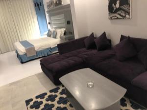ein Wohnzimmer mit einem Sofa und einem Bett in der Unterkunft Manazeli Jeddah - in Dschidda