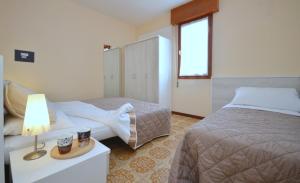 ビビオーネにあるAppartamenti Torre Panoramaのベッド2台、テーブル(ランプ付)が備わる客室です。