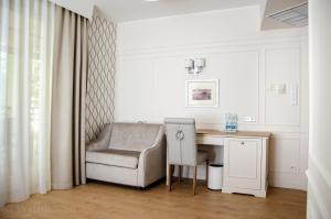 Dieses weiße Zimmer verfügt über einen Stuhl und einen Schreibtisch. in der Unterkunft Hotel Villa Baltica in Sopot