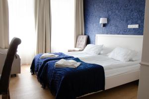 a bedroom with a bed with a blue wall at Hotel Villa Baltica in Sopot