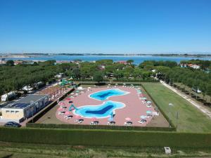 an aerial view of a large swimming pool with umbrellas at Camping Village Miramare in Cavallino-Treporti