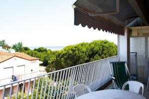 un portico con tavolo e sedie su un balcone di Appartamenti Angela e Pordenone a Bibione
