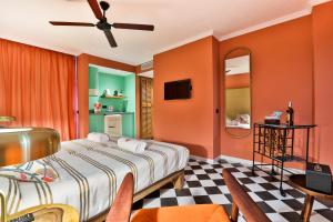 a bedroom with orange walls and a bed and chairs at Cubanito Ibiza in San Antonio