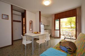 una cucina e un soggiorno con tavolo e sedie di Appartamenti Angela e Pordenone a Bibione