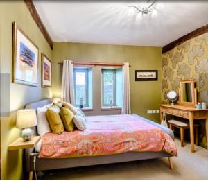 um quarto com uma cama com almofadas amarelas e uma secretária em Chestnut Lodge em East Dereham