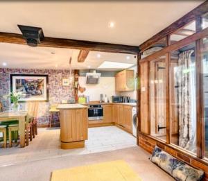 a kitchen with wooden cabinets and a dining room at Chestnut Lodge in East Dereham