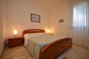 una camera da letto con un letto e due lampade sui tavoli di Appartamenti Angela e Pordenone a Bibione