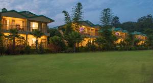 a large house with a lawn in front of it at Winsome Resort & Spa Corbett in Rāmnagar
