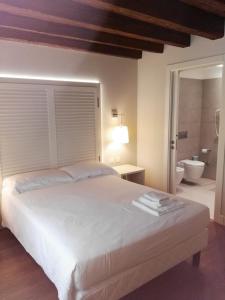 a hotel room with a white bed and white walls at Agriturismo Villa Trovatore in Cervignano del Friuli