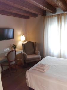 a hotel room with a bed and a television at Agriturismo Villa Trovatore in Cervignano del Friuli