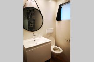 a bathroom with a sink and a toilet and a mirror at L'horizon 2 - bord de mer in Ploemeur