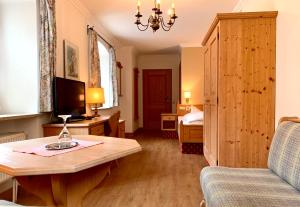 a living room with a couch and a table with a television at Hotel zur Post in Kochel