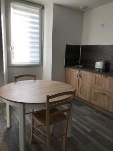 een keuken met een tafel en 2 stoelen en een raam bij La belle Epoque in Damparis