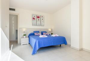 1 dormitorio con 1 cama azul y 2 almohadas en Apart-rent Apartment Francesc Macia Penthouse 2000, en Roses