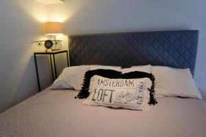 łóżko z niebieskim zagłówkiem i poduszką w obiekcie Holiday Home LOFT w mieście Międzyzdroje
