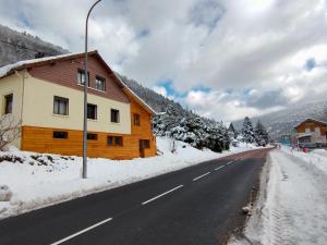 una casa al lado de una carretera cubierta de nieve en Gite de L'ours, en La Bresse