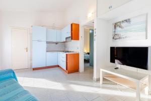 een keuken met witte kasten en een tv in een kamer bij Trilocale a 200 mt dal centro in San Teodoro