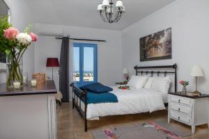 Sunrise Apartment Santorini في Emporio: غرفة نوم بسرير ومكتب ونافذة