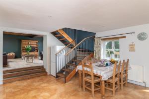 a dining room with a table and a staircase at Orchard House in Rosedale Abbey