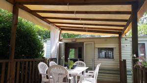 pérgola de madera en una terraza con mesa y sillas en Li Sourso, en Aups