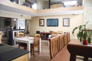 a dining room with a table and chairs and a tv at African BnB - The Boutique Experience in Benoni