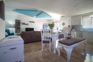 Sunrise Apartment Santorini في Emporio: مطبخ وغرفة معيشة مع طاولة وكراسي