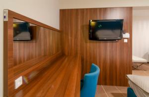 a room with two televisions on a wall at Holiday Home Aparthotel in Międzyzdroje