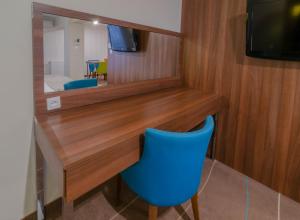 biurko z niebieskim krzesłem i lustrem w obiekcie Holiday Home Aparthotel w mieście Międzyzdroje