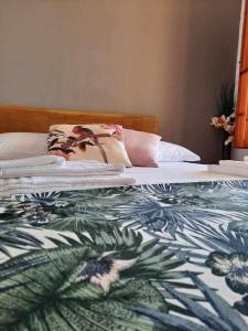 a bed with a floral comforter on top of it at Aloha Marzamemi Rooms in Marzamemi