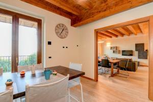 jadalnia i salon z zegarem na ścianie w obiekcie Villa Sinfonia w mieście Polpenazze del Garda