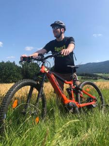 Ein Mann steht neben einem Fahrrad auf einem Feld in der Unterkunft Müller´s Landhotel in Mespelbrunn