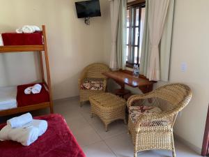 Cette chambre comprend un lit, des chaises et une table. dans l'établissement Black Point Beach Club, à Maricá