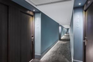 un couloir d'ascenseurs dans un bâtiment aux murs bleus dans l'établissement B&B HOTEL Donostia Aeropuerto, à Oiartzun