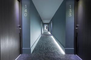 einen leeren Korridor mit blauen Wänden und einem langen Flur in der Unterkunft B&B HOTEL Donostia Aeropuerto in Oiartzun