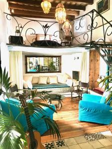 ein Wohnzimmer mit blauen Sofas und einer Gitarre in der Unterkunft CASA PUERTA AZUL Absolutely the Best of Vejer! Casas Vejer Debra in Vejer de la Frontera