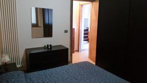 a bedroom with a bed and a dresser and a mirror at Hotel Europa Beach Village in Giulianova