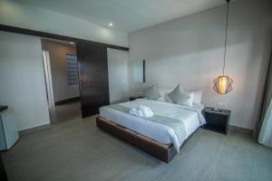 a bedroom with a large white bed in a room at Ren Resort in Sihanoukville
